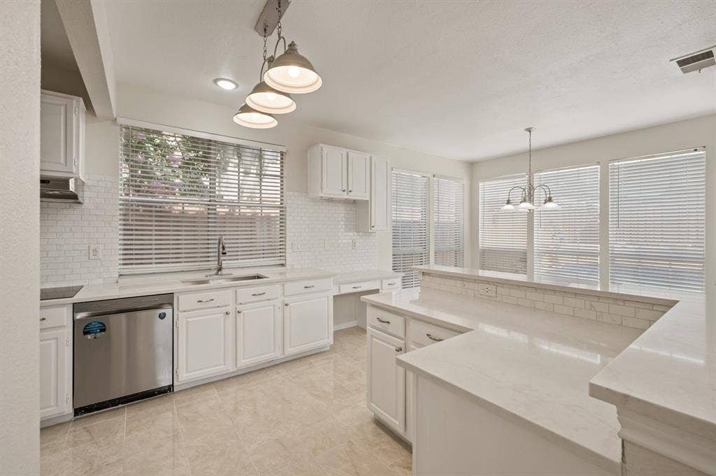 669 Water Oak Drive, Plano, TX 75025 Kitchen featuring white cabinetry, light-toned countertops, a subway tile backsplash, and light-toned tile flooring