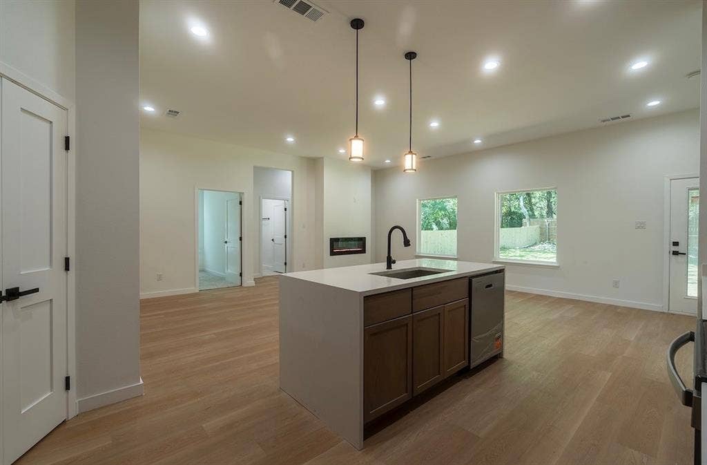 3315 Kyser, Dallas, TX 75216 Kitchen island with a built-in sink and dishwasher, featuring pendant lighting and recessed lighting throughout