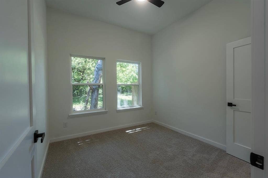 3315 Kyser, Dallas, TX 75216 Interior room featuring two windows, neutral carpeting, and a ceiling fan