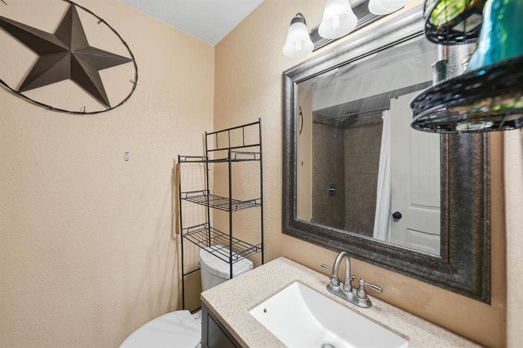 520 Thompson Drive, Saginaw, TX 76179 Bathroom vanity with an integrated sink, dual-handle faucet, and framed wall mirror