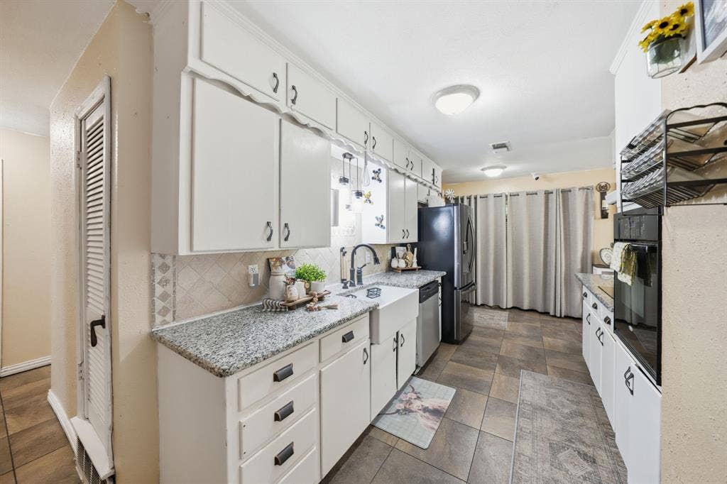 520 Thompson Drive, Saginaw, TX 76179 Kitchen featuring white cabinetry, granite-finish countertops, and an integrated stainless steel dishwasher