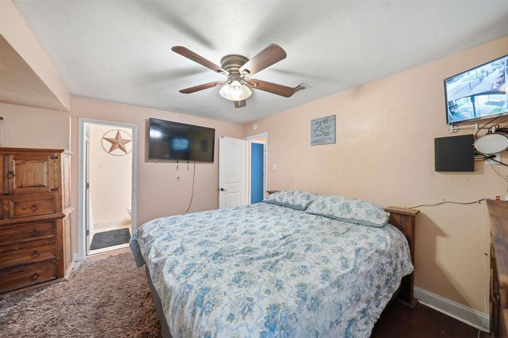520 Thompson Drive, Saginaw, TX 76179 Bedroom featuring a ceiling fan with integrated lighting, wall-mounted television, and a separate doorway