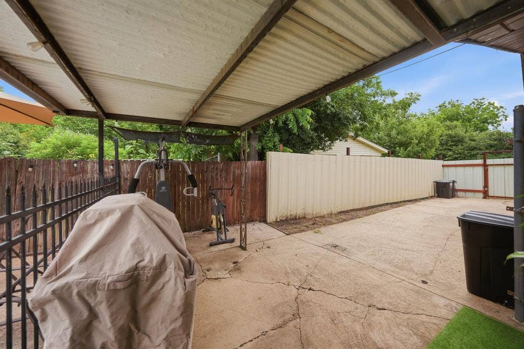 520 Thompson Drive, Saginaw, TX 76179 Covered patio area featuring a corrugated roof, open structural beams, and concrete flooring