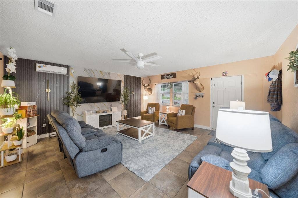 520 Thompson Drive, Saginaw, TX 76179 Spacious living area featuring tile flooring, a ceiling fan, and a wall-mounted entertainment console with an electric fireplace