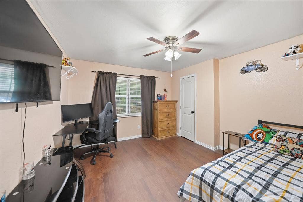 520 Thompson Drive, Saginaw, TX 76179 Bedroom featuring wood-finish flooring, a ceiling fan with integrated lighting, and a window with blinds and dark curtains