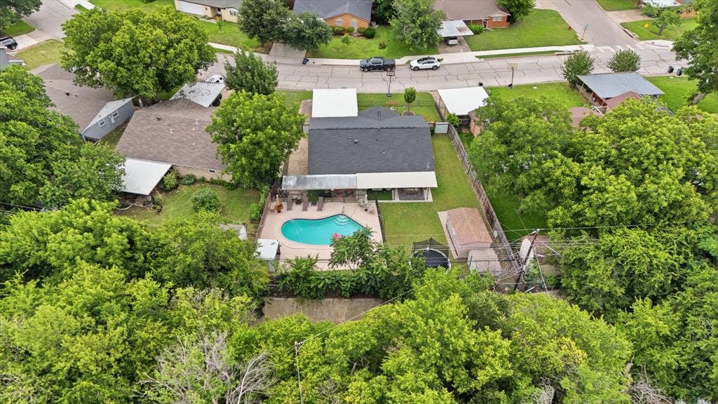 520 Thompson Drive, Saginaw, TX 76179 Backyard oasis featuring an in-ground swimming pool with surrounding patio, mature landscaping, and a fenced perimeter