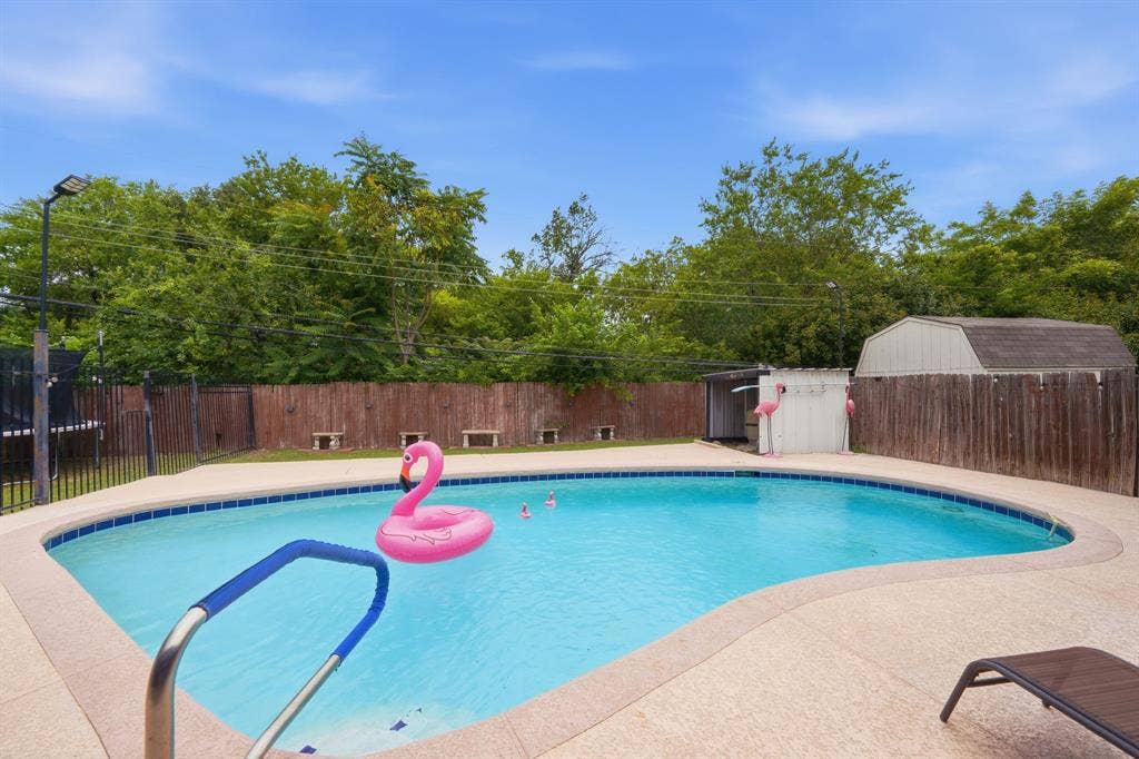 520 Thompson Drive, Saginaw, TX 76179 Curved swimming pool with light-colored coping and a surrounding concrete deck