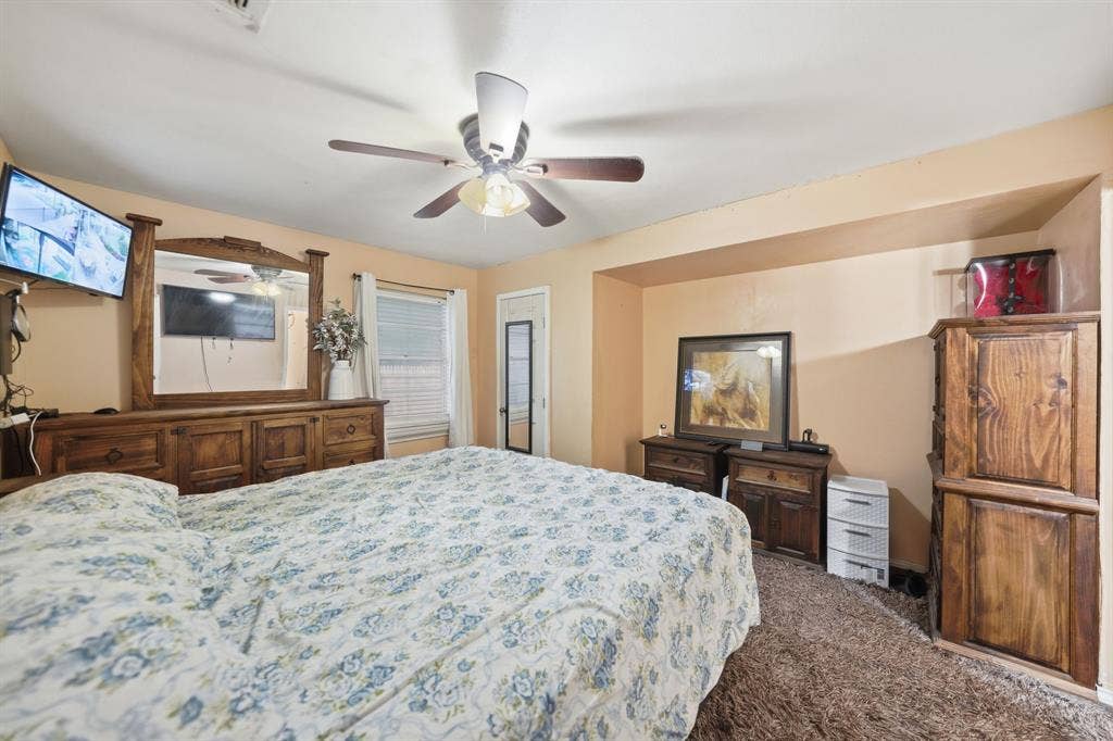 520 Thompson Drive, Saginaw, TX 76179 Carpeted bedroom featuring a ceiling fan, a window with blinds, and an alcove