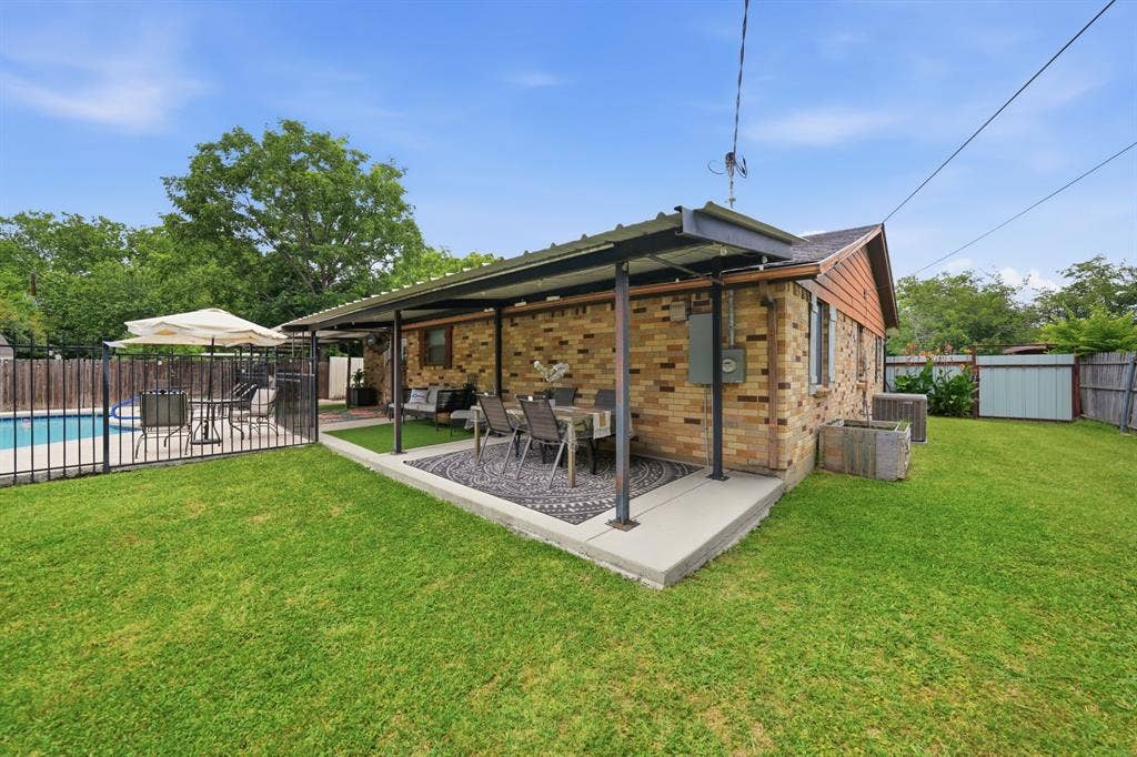 520 Thompson Drive, Saginaw, TX 76179 Expansive backyard featuring a covered patio, brick exterior, fenced swimming pool area, and a storage shed