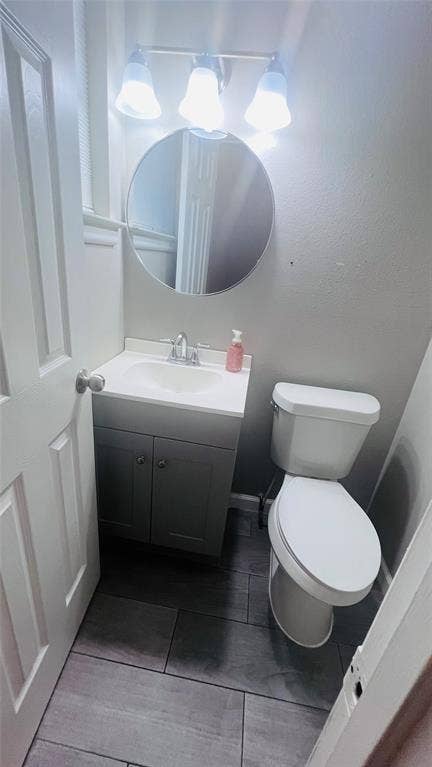909 Laguna Drive, Denton, TX 76209 Bathroom featuring a single-sink vanity with white countertop, chrome faucet, and gray cabinetry