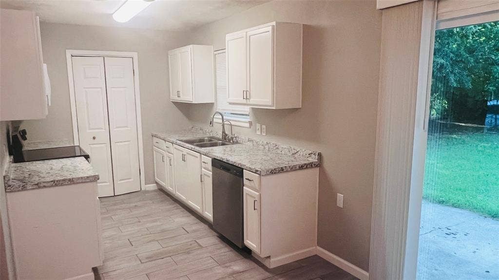 909 Laguna Drive, Denton, TX 76209 Kitchen featuring white shaker cabinetry, speckled countertops, stainless steel appliances, and wood-finish flooring