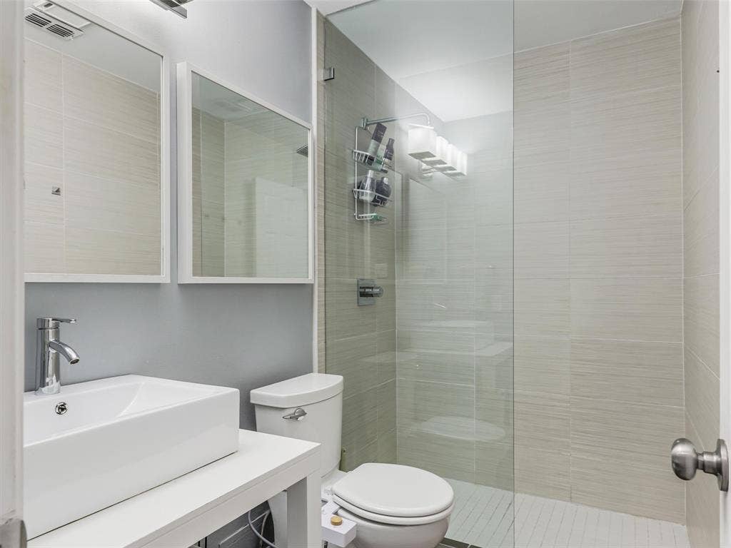 6701 Vero Drive, Plano, TX 75023 Bathroom two featuring a rectangular vessel sink, chrome faucet, and dual mirrors.