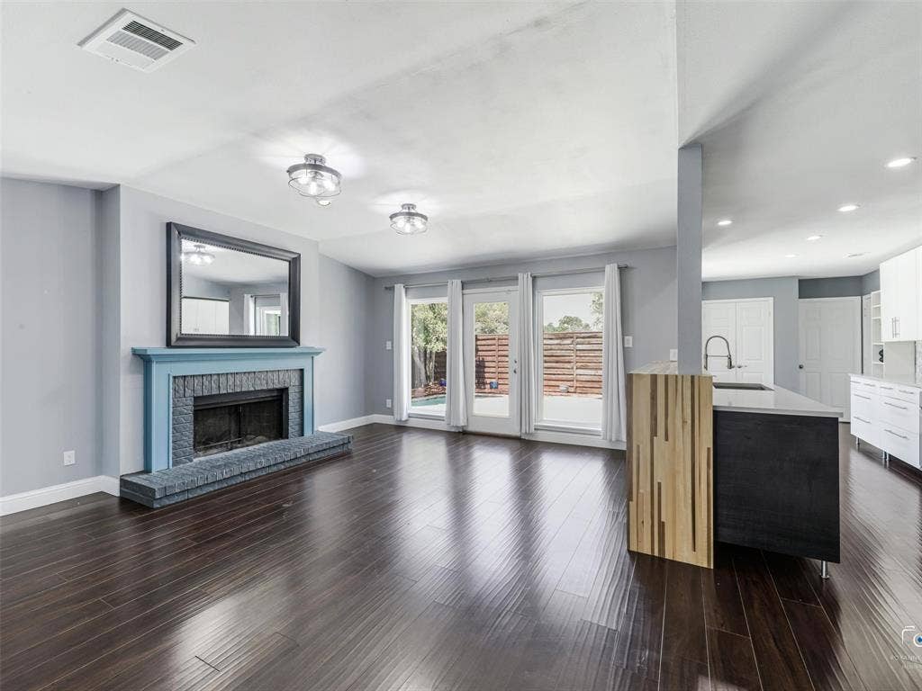 6701 Vero Drive, Plano, TX 75023 Spacious living area has a lovely fireplace with a hearth and is open to the kitchen and pool-filled backyard.