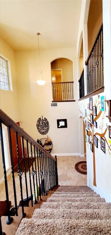 104 Rustic Oak Lane, McKinney, TX 75072 Two-story entry featuring a carpeted staircase with wrought iron balusters, wood handrails, and a stained glass window