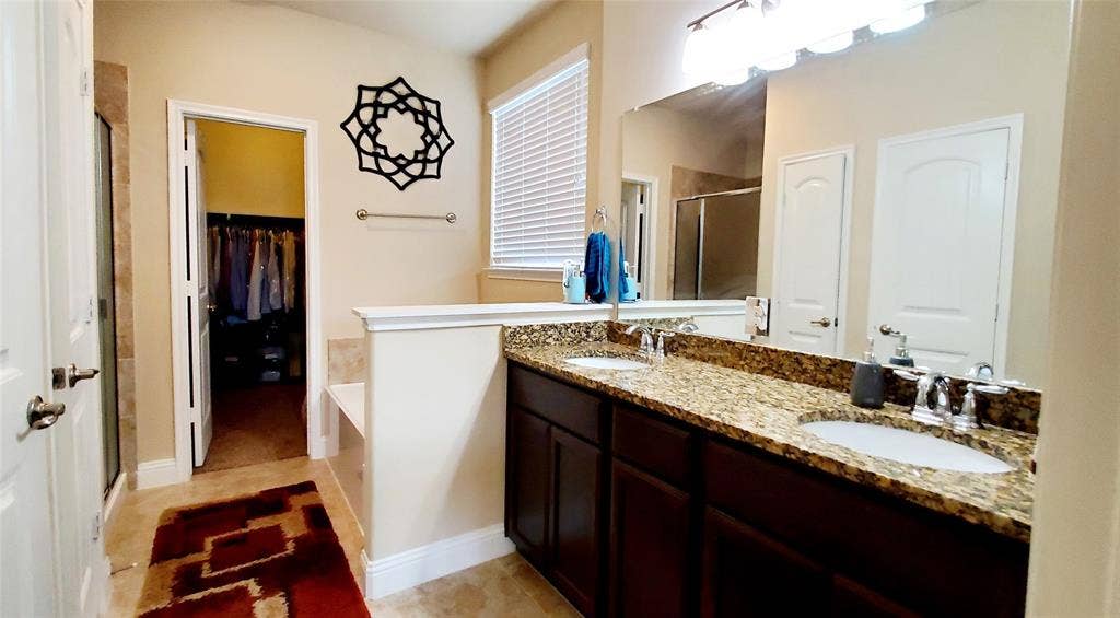 104 Rustic Oak Lane, McKinney, TX 75072 Bathroom with a dual vanity featuring a granite countertop and dark wood cabinetry