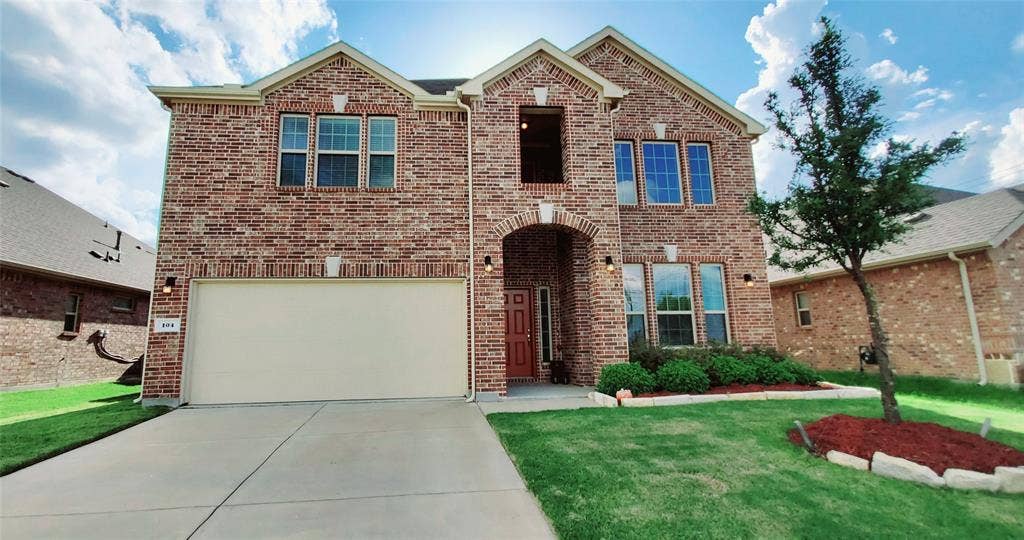 104 Rustic Oak Lane, McKinney, TX 75072 Brick exterior residence featuring an arched entry, two-story facade, and an attached garage