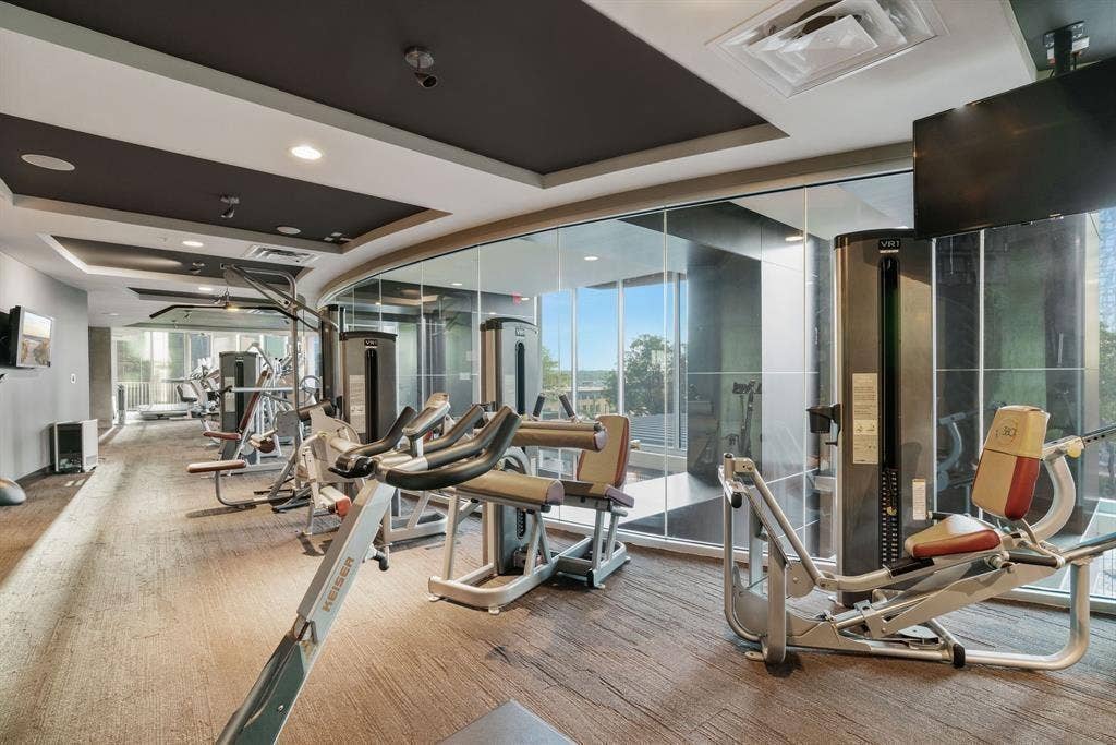 360 Nueces Street, #2110, Austin, TX 78701 Fitness center featuring a variety of exercise equipment, carpet flooring, a drop ceiling with recessed lighting, and expansive windows