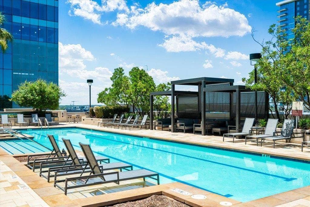 360 Nueces Street, #2110, Austin, TX 78701 Outdoor swimming pool with integrated lighting, surrounded by stone paver decking