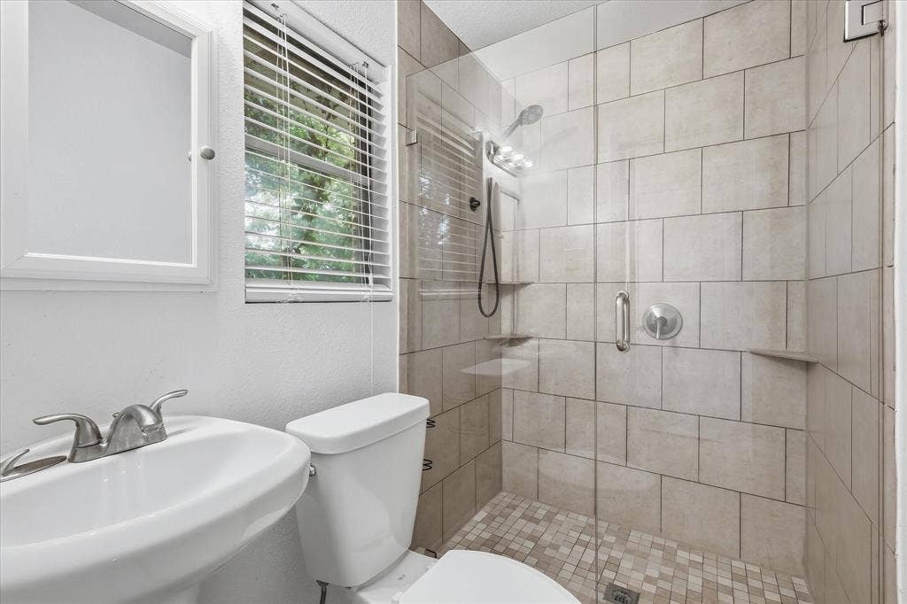 Walk-in shower featuring a frameless glass enclosure and large format wall tiling