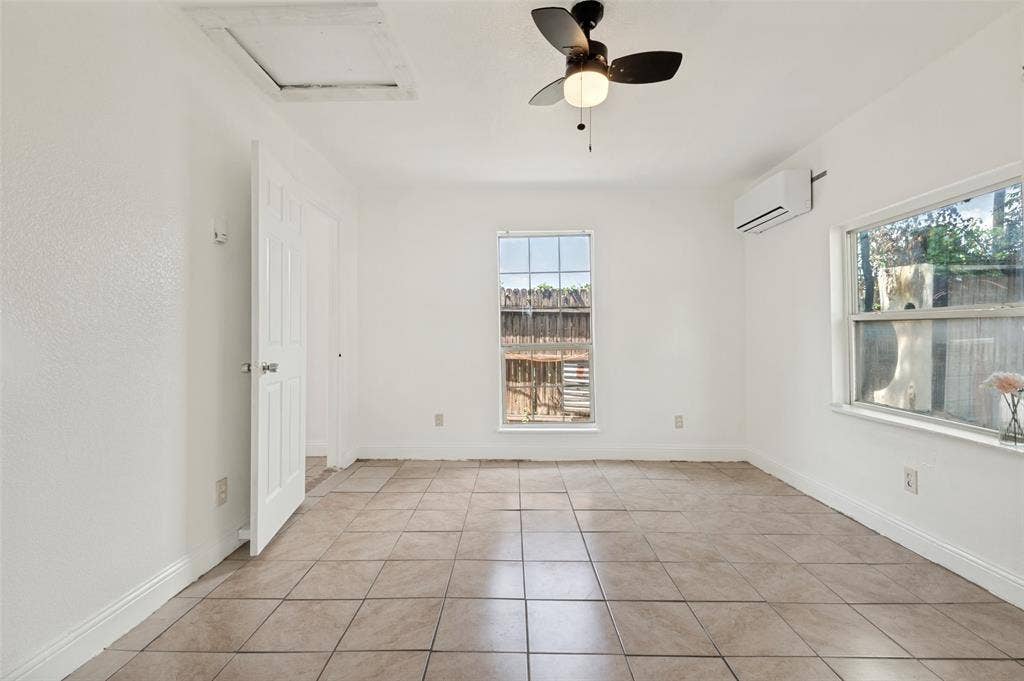 403 N Britain Road, #407B, Irving, TX 75061 Bright room featuring neutral tile flooring, white walls, two windows, and a ceiling fan with integrated lighting