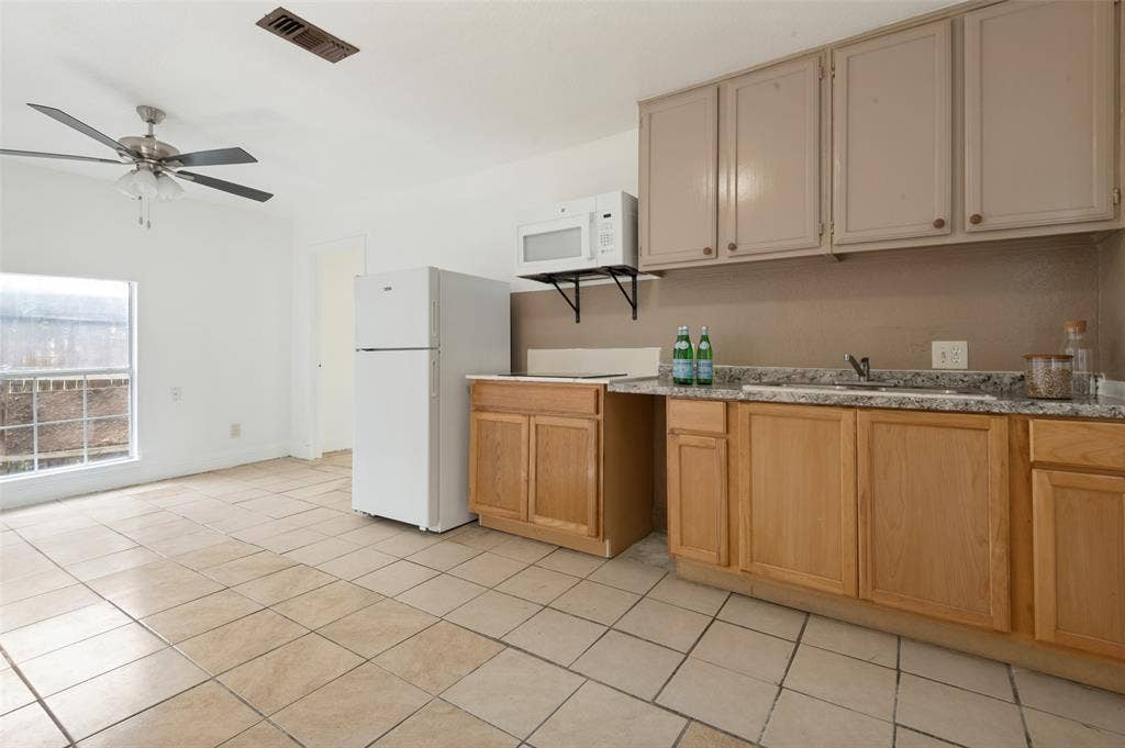 403 N Britain Road, #407B, Irving, TX 75061 Kitchenette with tile flooring, light wood-finish base cabinetry, and contrasting upper cabinetry