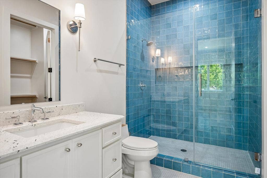 3304 Townsend Drive, Dallas, TX 75229 Bath, blue glazed tile shower, frameless glass enclosure, stone countertop, shower niche