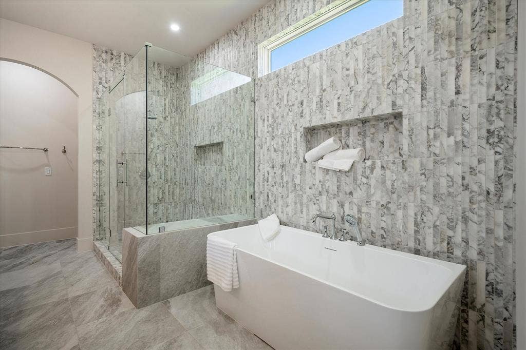 3304 Townsend Drive, Dallas, TX 75229 Primary bath, freestanding soaking tub, Calacatta Giallo tile surround, shower niche, clerestory window