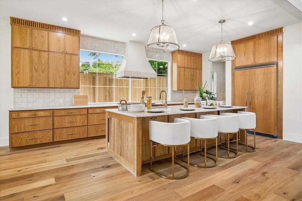3304 Townsend Drive, Dallas, TX 75229 Custom oak cabinetry, Taj Mahal leathered quartzite island with bar seating, panel-ready refrigerator