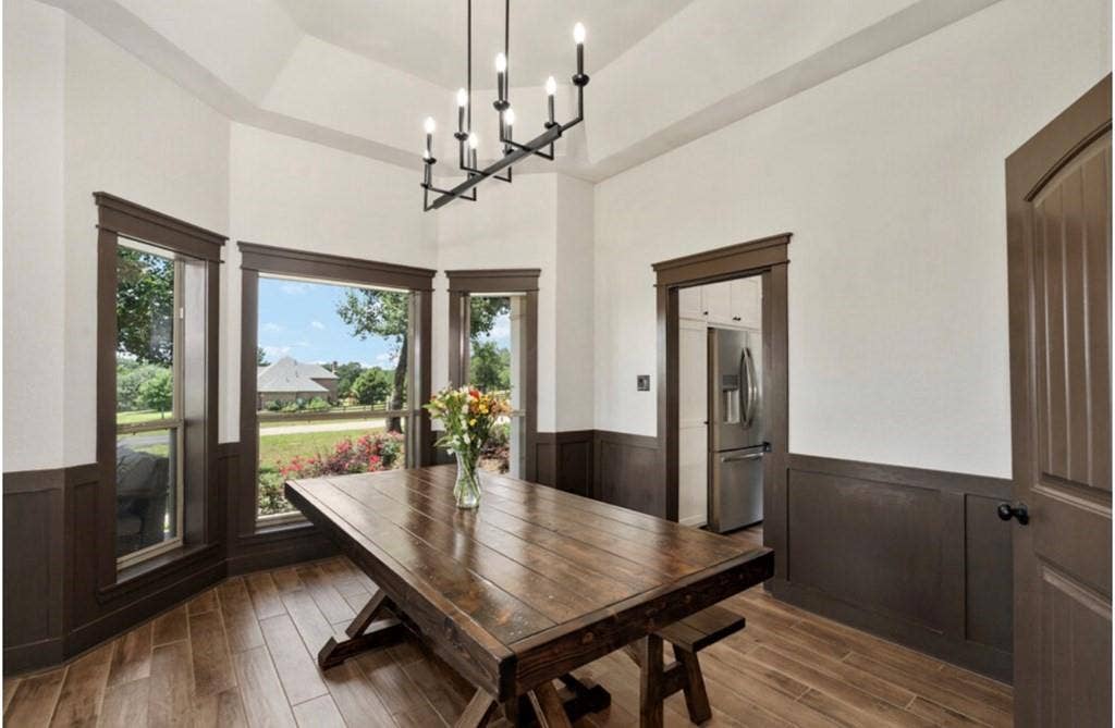 106 Timber Hill, Athens, TX 75751 Room featuring a vaulted ceiling, wood-finish flooring, and dark wainscoting