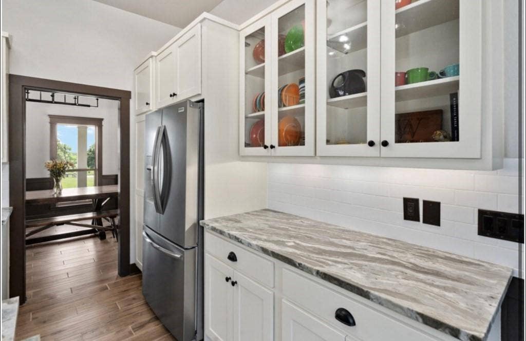 106 Timber Hill, Athens, TX 75751 Kitchen area featuring white shaker-style cabinetry, glass-front upper cabinets, and a stainless steel refrigerator