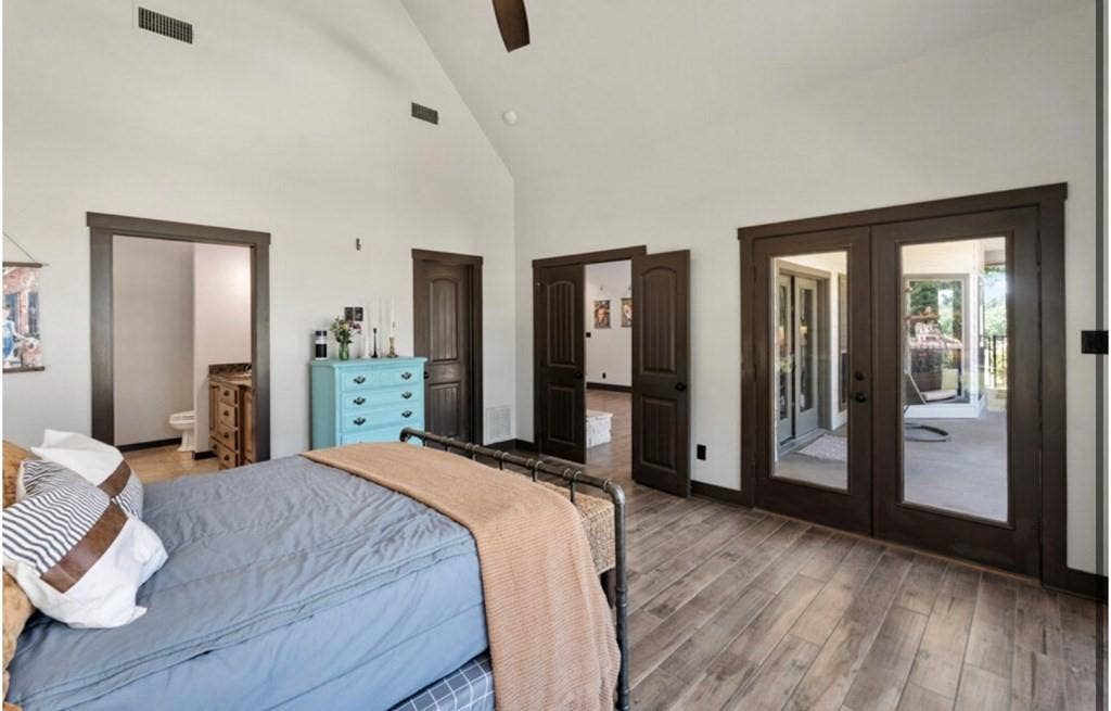 106 Timber Hill, Athens, TX 75751 Vaulted ceilings with exposed beams, wood-finish flooring, dark wood trim throughout, and French doors leading to an outdoor space