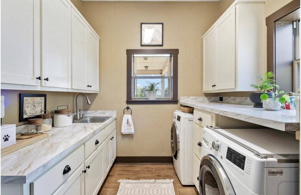 106 Timber Hill, Athens, TX 75751 Dedicated utility space featuring extensive cabinetry, integrated sink, durable countertops, wood-finish flooring, and a framed window