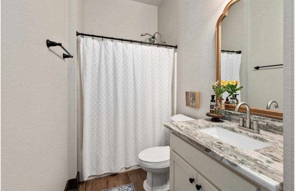 106 Timber Hill, Athens, TX 75751 Bathroom featuring a white vanity with black cabinet hardware, a patterned countertop, and an undermount sink with a brushed nickel faucet