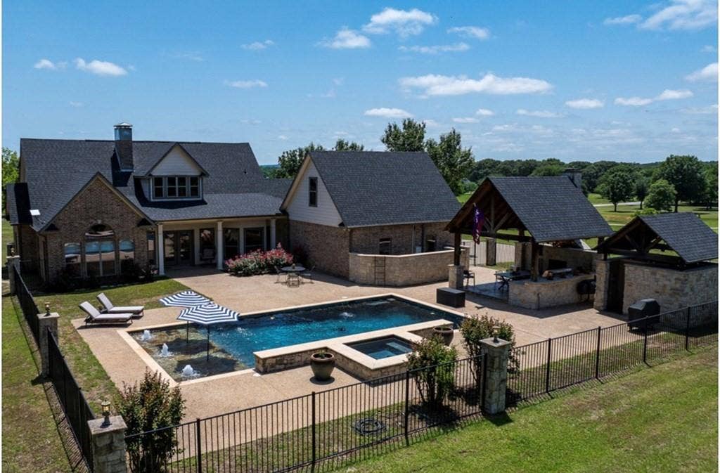 106 Timber Hill, Athens, TX 75751 Outdoor living area featuring a rectangular pool with integrated spa, a separate water feature, and extensive hardscaping