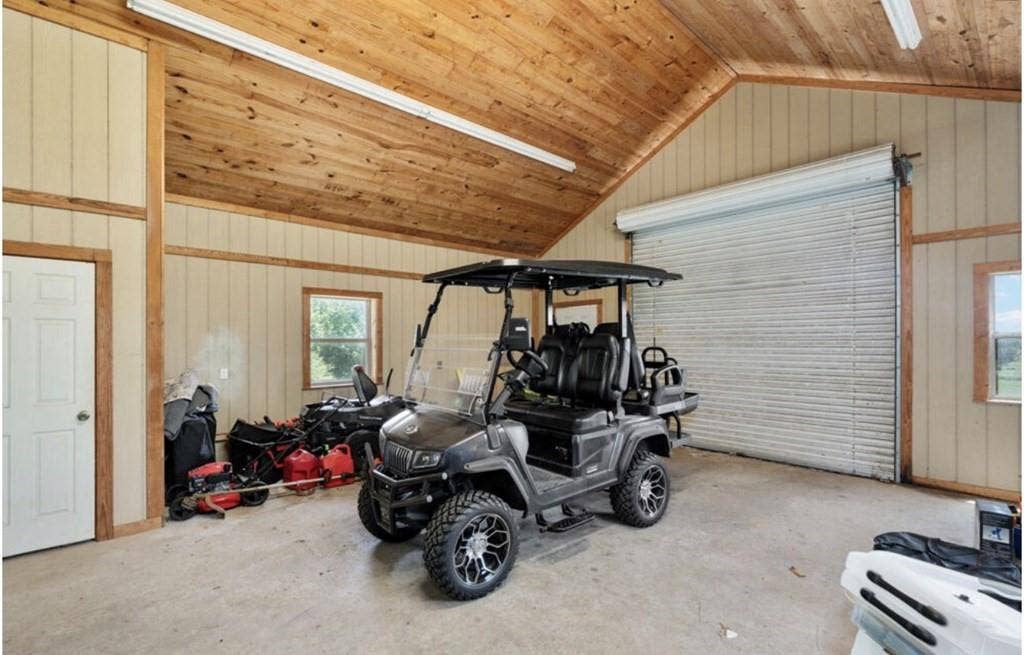 106 Timber Hill, Athens, TX 75751 Spacious outbuilding featuring a large roll-up door, exposed wood ceiling, and concrete flooring