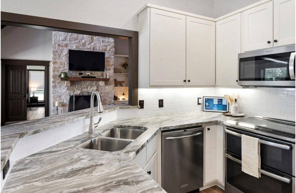 106 Timber Hill, Athens, TX 75751 Kitchen featuring a double stainless steel sink, patterned stone countertops, white shaker-style cabinetry, and stainless steel appliances