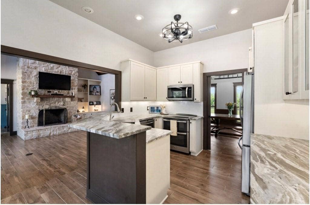 106 Timber Hill, Athens, TX 75751 Kitchen featuring wood-finish flooring, white cabinetry, stainless steel appliances, and light-toned countertops