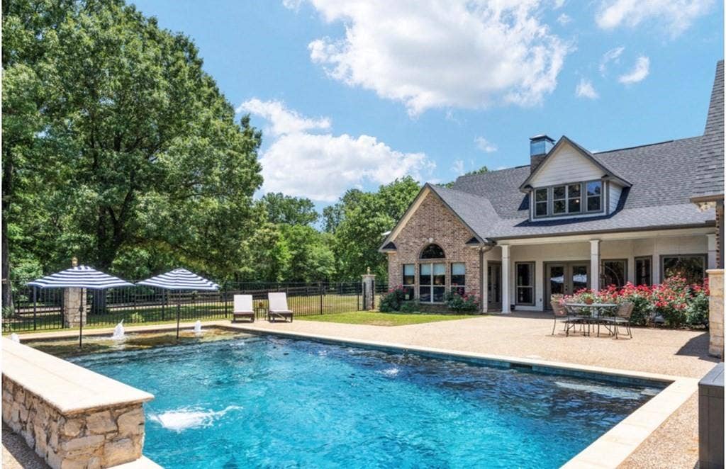 106 Timber Hill, Athens, TX 75751 Resort-style pool with integrated fountains, a surrounding stone deck, and a dedicated patio area