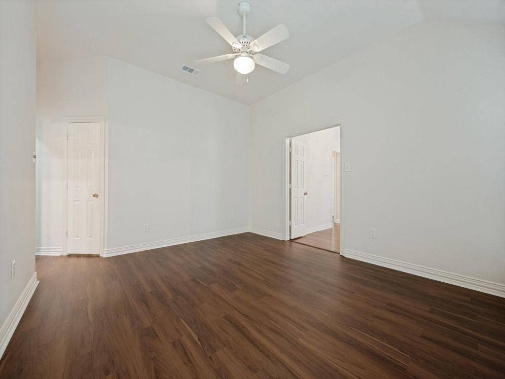 9703 Raven Lane, Irving, TX 75063 Vaulted ceiling room featuring wood-finish flooring, a white ceiling fan with integrated lighting, and white baseboards