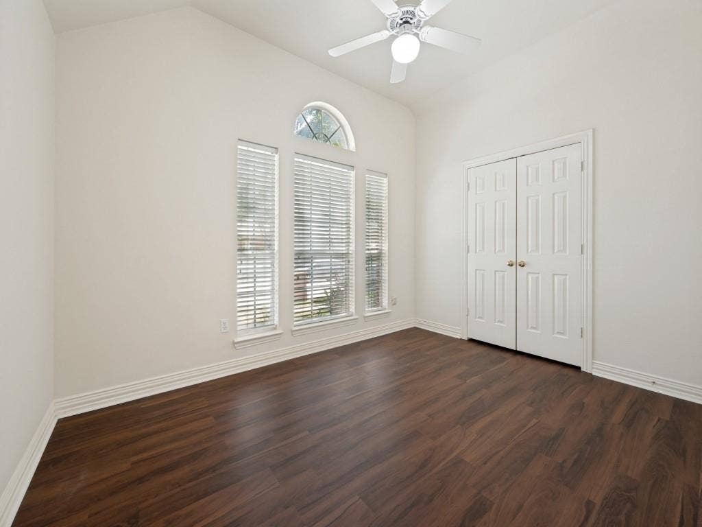 9703 Raven Lane, Irving, TX 75063 Vaulted ceiling room featuring wood-finish flooring, white walls, and a ceiling fan
