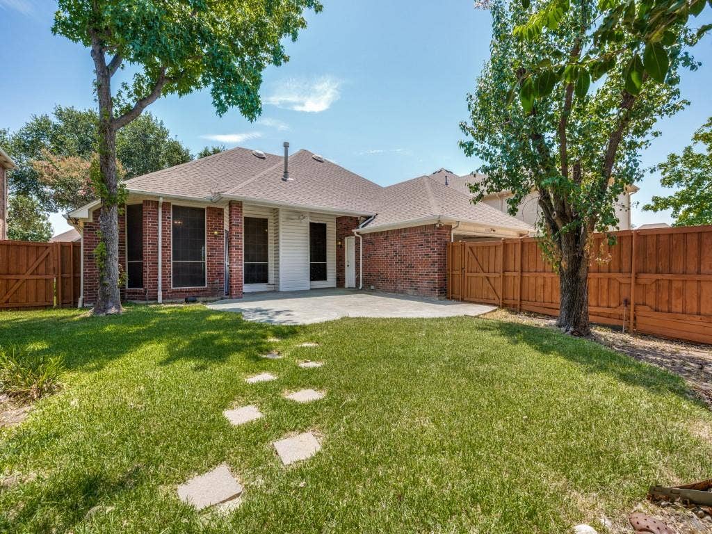 9703 Raven Lane, Irving, TX 75063 Private backyard featuring a concrete patio, stepping stones, and a full wood fence