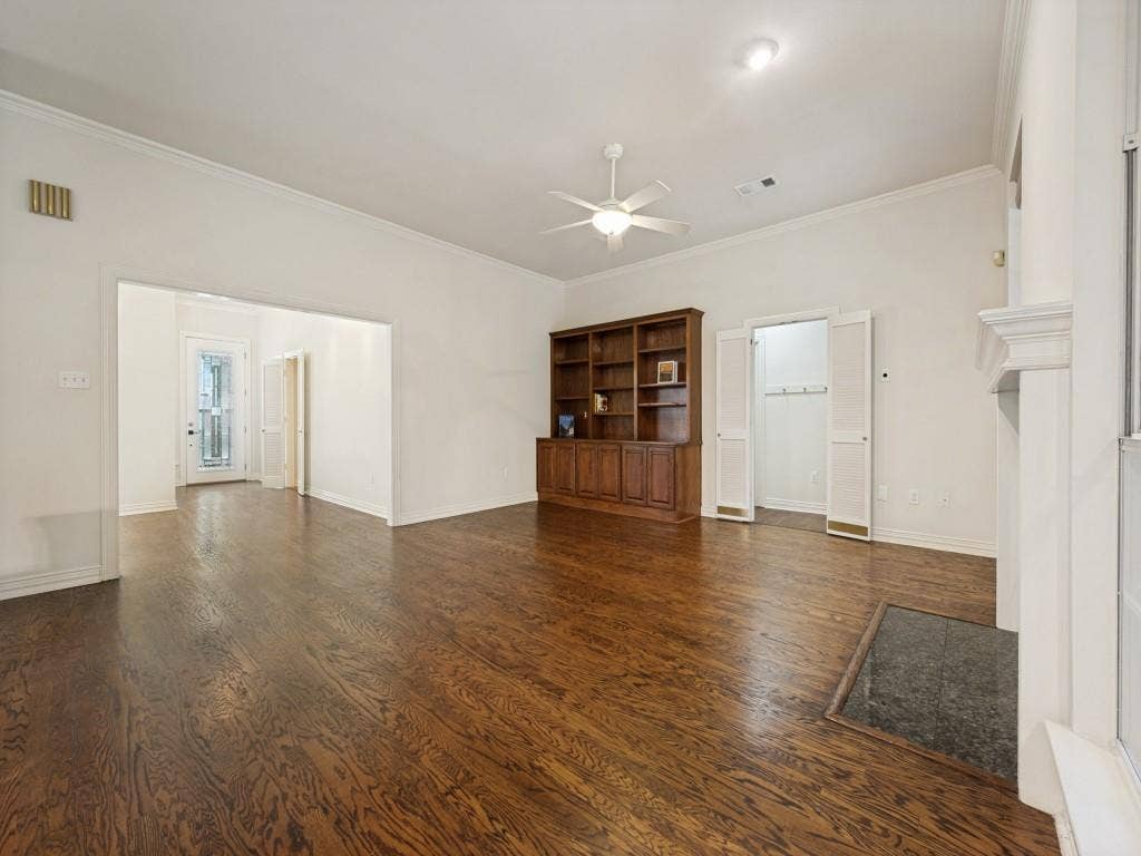 9703 Raven Lane, Irving, TX 75063 Expansive living area featuring rich wood-finish flooring and a built-in wood bookcase