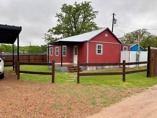 5280 Atwell Lane, #B, Denton, TX 76208 Red-sided residence featuring a metal roof, covered front porch with steps, and galvanized skirting