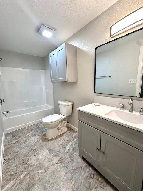 5280 Atwell Lane, #B, Denton, TX 76208 Full bathroom featuring a single vanity with a white countertop and undermount sink, a framed mirror, a tub/shower combination, and patterned flooring