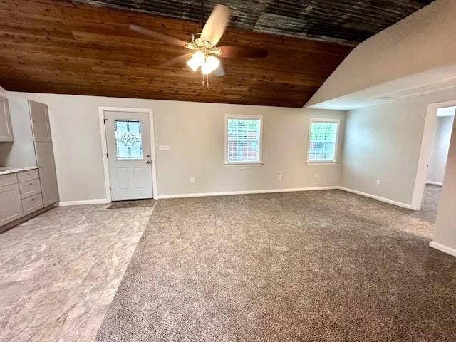 5280 Atwell Lane, #B, Denton, TX 76208 Open concept living area featuring a wood-panel ceiling with a ceiling fan, light gray painted walls, and an entryway with a decorative glass door