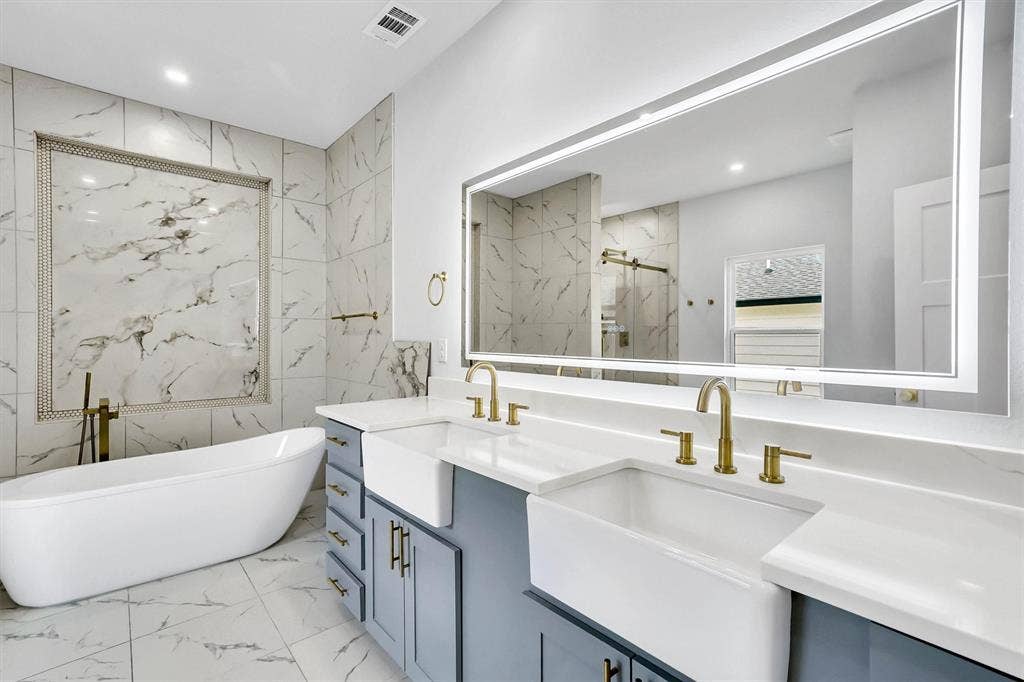 Freestanding soaking tub with a floor-mounted brass faucet