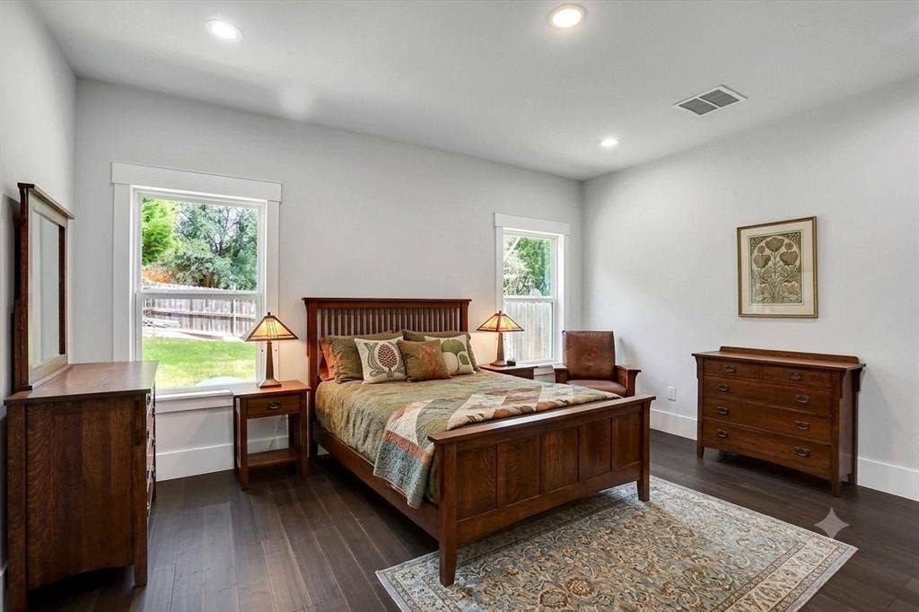 Spacious room featuring wood-finish flooring, recessed lighting, and two large windows with white trim