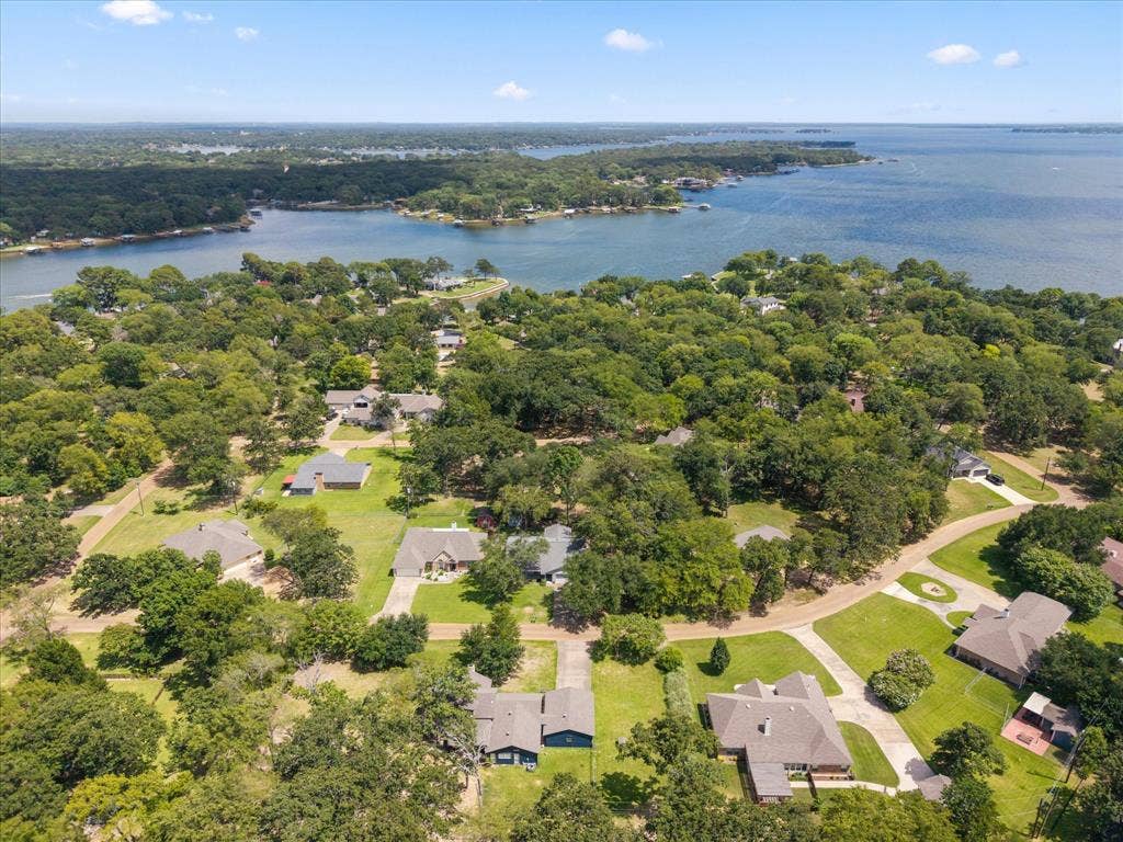 116 Meadowood Road, Enchanted Oaks, TX 75156 Aerial perspective showcasing a residential area with varied architectural styles, mature trees, and extensive green landscaping