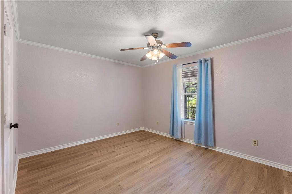 116 Meadowood Road, Enchanted Oaks, TX 75156 Light-filled room featuring wood-finish flooring, a ceiling fan with integrated lighting, and crown molding