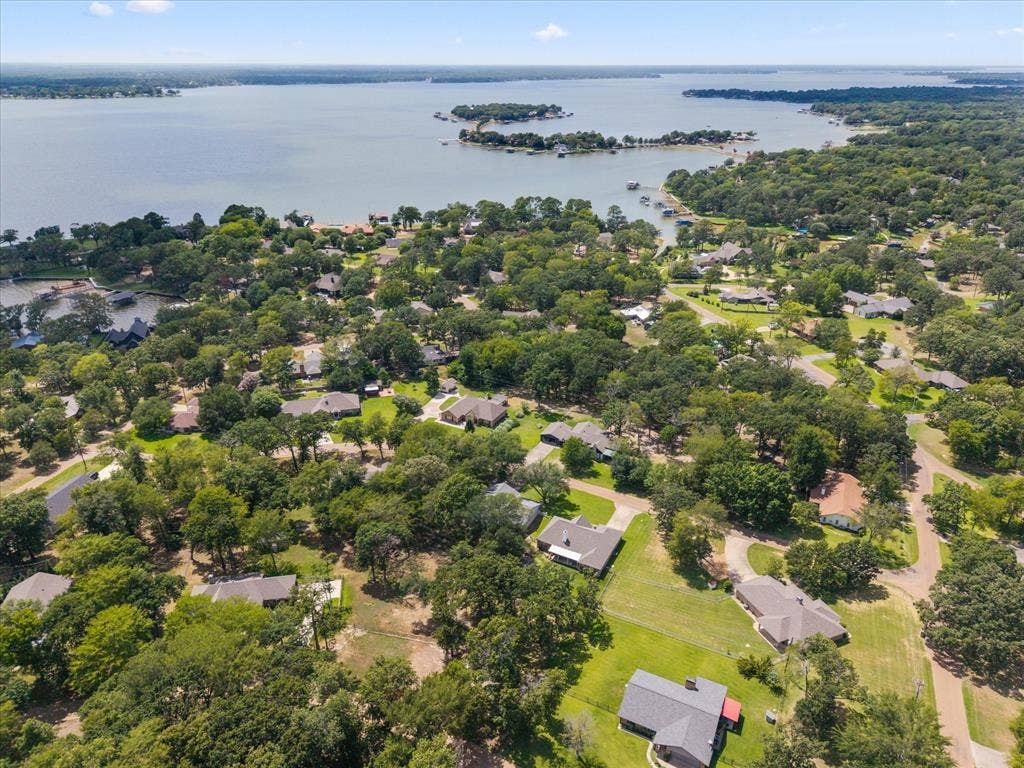 116 Meadowood Road, Enchanted Oaks, TX 75156 Lakefront community featuring a calm body of water, extensive tree cover, multiple residential properties, and private boat docks